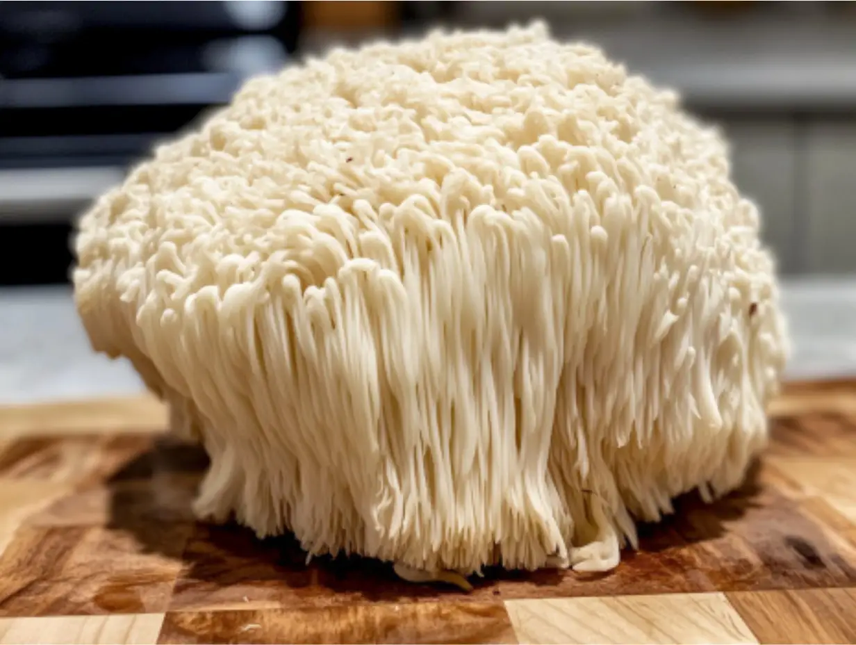 Fresh lion’s mane mushroom on a wooden cutting board.